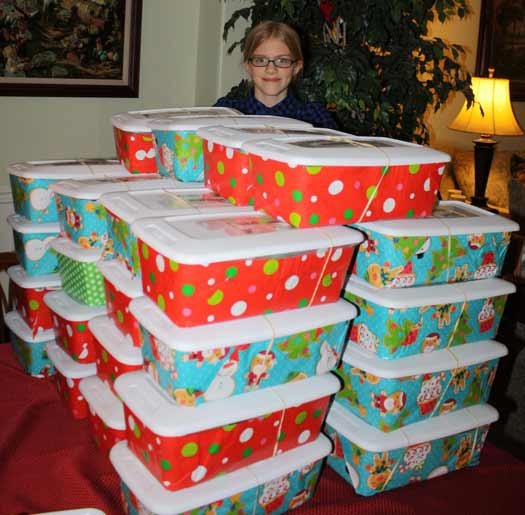 Rachel Quick is dwarfed behind a small pile of boxes she sent out as part of Operation Christmas Child.