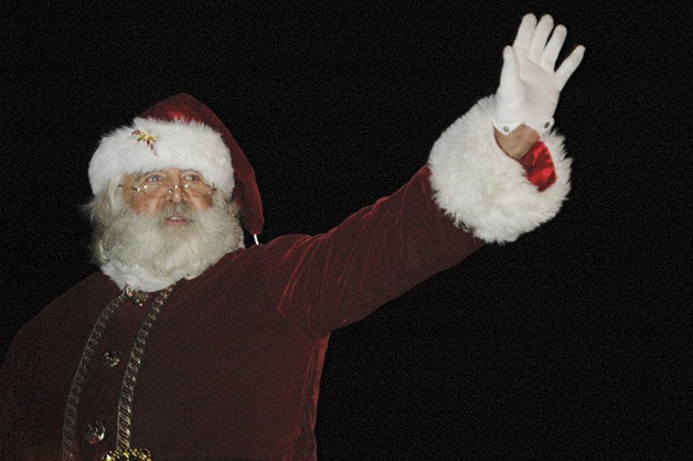 Santa Claus waves to the kids during the Holiday Parade in Enumclaw Saturday
