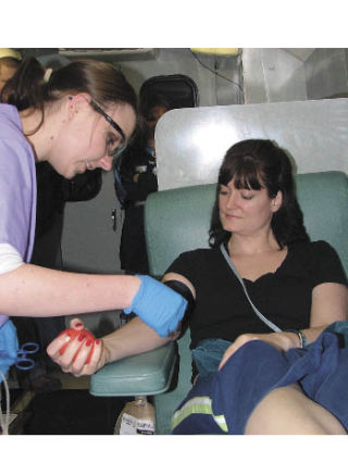 Tiffany Roberts of Bonney Lake became a first-time blood donor Friday at Bonney Lake Senior Center’s blood drive. Sarah Johnson works for Cascade  Regional Blood  Services.  Photo by Judy Halone