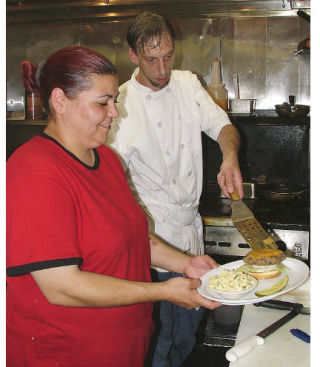 Ruby Iribarren and her husband Brian Britton prepare a customer’s order July 25 at Sully’s Alder Street Café in Sumner.