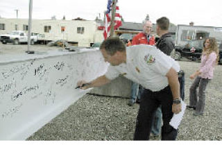 Buckley Fire Chief Alan Predmore puts his John Hancock on the hospital’s memorial beam.