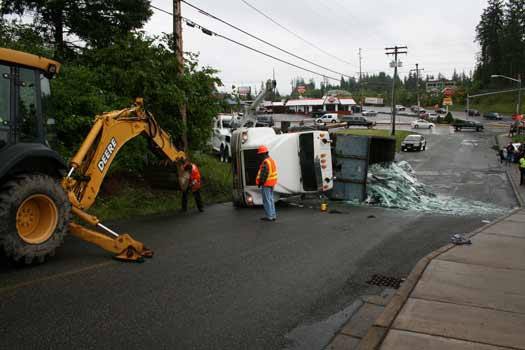 Workers attempt to right a truck that rolled on its side Wednesday morning