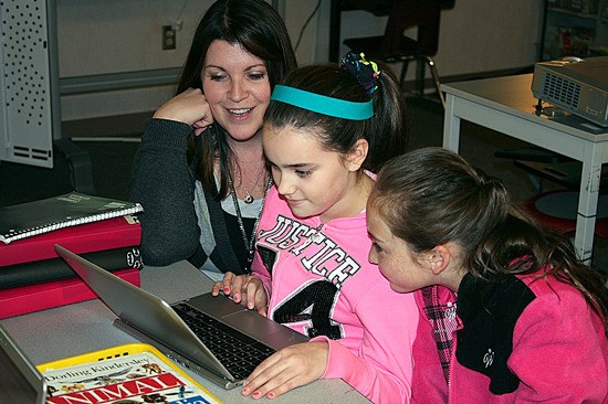 Kennedy and Olivia learn to work their classroom's Chromebook with their teacher