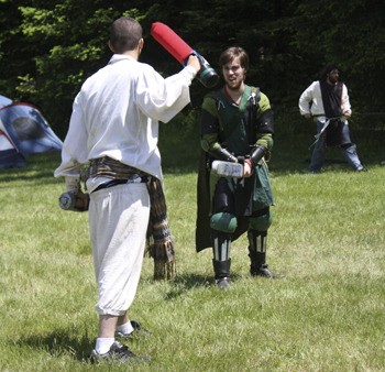 Two Live Action Roleplayers face off in a clearing near the Fantasy Faire tent city.