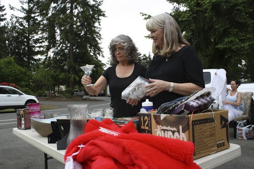 Geri and Marilyn Janz examine a martini glass at one of the few driveways still open to bargain hunters during the final afternoon of the Tapps Island neighborhood garage sale. The garage sale was held June 4-5.