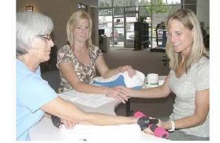 Maureen Hart and Jennifer Ferrell learn about hand therapy from Brandy Campbell Friday at Bonney Lake Physical Therapy and Hand Rehab.