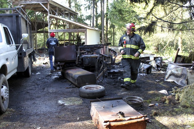 Battalion Chief Greg Reinke examines the remains of a burned motor home Wednesday.