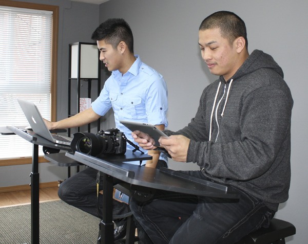 Graphic designer Gabe Tam and photographer Chris Carino review photos in their studio office. Carino
