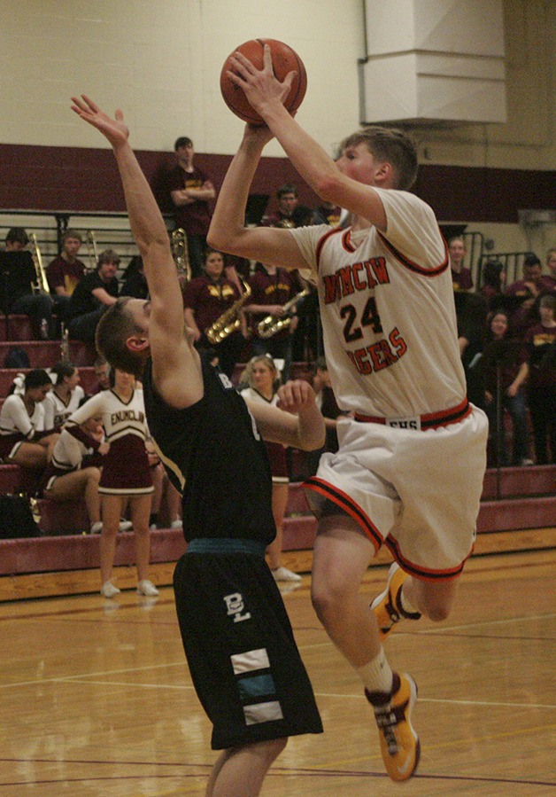 Enumclaw sophomore Josh Erickson eyes the basket during the game. Donning throwback jerseys of the Enumclaw Tigers