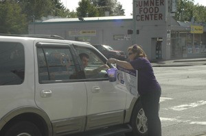 Tina Pries collects donations for the American Cancer Society during Paint the Town Purple in Sumner on Wednesday.