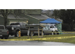 Police investigators tape off an area in front of the residence where a 60-year-old Sumner woman was found dead.