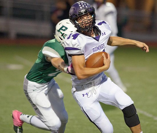 Josh Riley earns yardage during the Sumner Spartans’ Thursday night victory at Peninsula High. The hard-fought win kept Sumner in a tie for first place in the SPSL 3A.