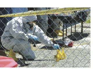 A Pierce County lab worker wears a protective suit and mask while cataloguing evidence discovered at a meth lab Friday in Sumner.