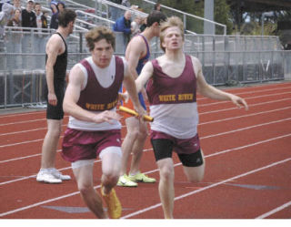 Collin Green takes the baton from Matt Dickson Thursday at White River during the Hornets’ record-setting 1