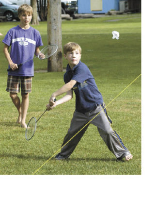 Atticus Wilkin watches a badminton birdie fall across the net during a block party Thursday at Loyalty Park in Sumner. His older brother