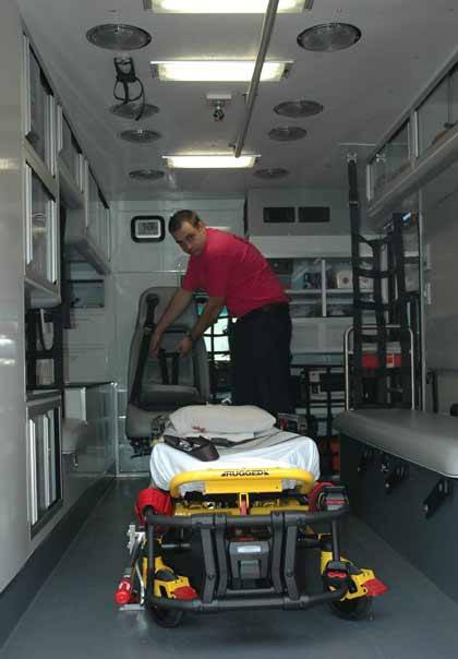 Enumclaw firefighter John Bloomer demonstrates the attendant and child chair feature of the department's latest aid car.