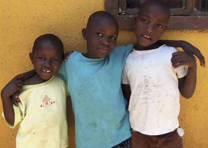 Three brothers  pose at a children’s home in Kampala