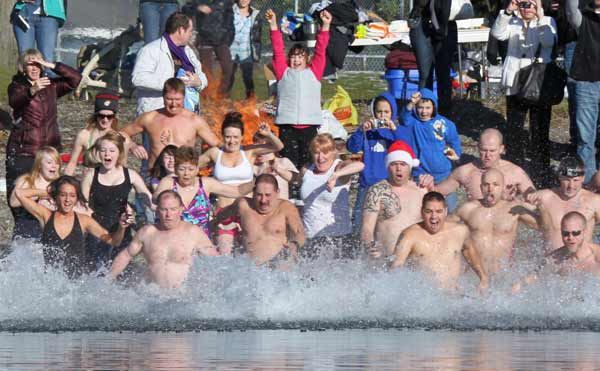Brave swimmers rush into Lake Tapps Jan. 1 as part of the Polar Bear Plunge at Driftwood Point Park.