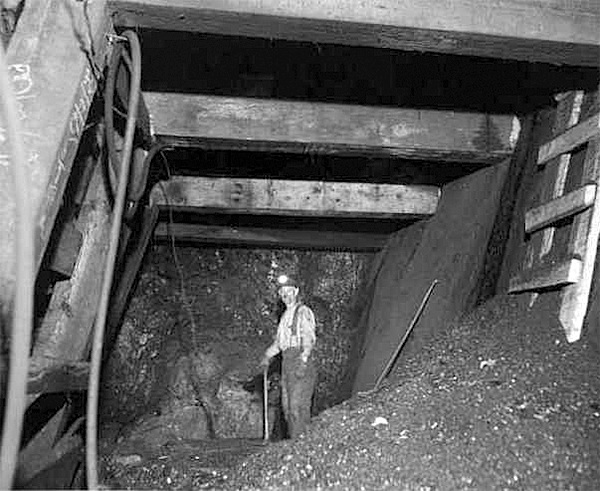 This photo of the interior of the mine shows miner Jim “Corkie” Kelly.  To the right is a ladder accessing a chute which is being driven up the coal seam.  This March 18
