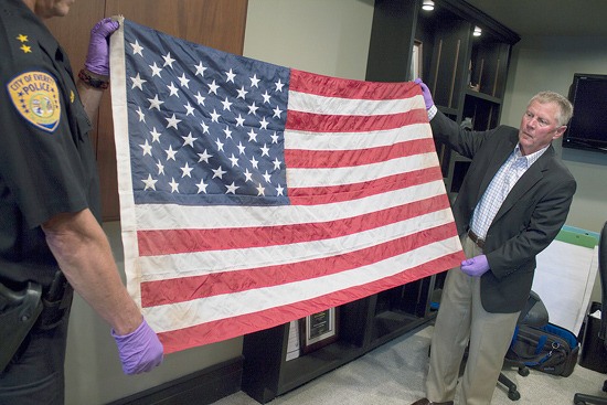 Everett Mayor Ray Stephanson (right) helps display a flag linked to a famous photo of ground zero in New York after the Sept. 11