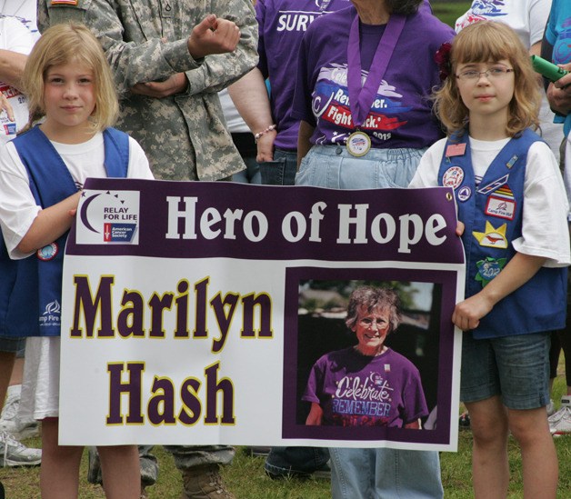 Campfire girls carry a Marilyn Hash  “Hero for Hope’’ sign around the track at J.J. Smith Saturday for the Relay for Life event.