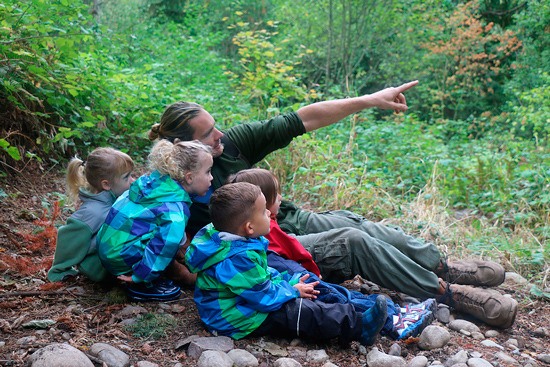 Timber Creek teacher Matt Fortin points out some woodpeckers to his students.