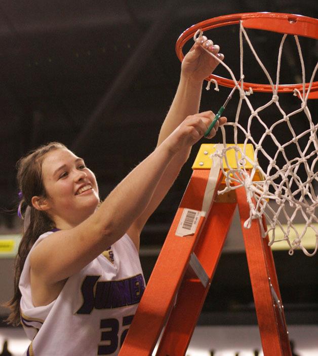 Sumner's Jamie Lange helps cut the basketball net down following the team's defeat of White River for the West Central District crown.