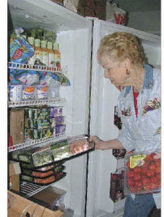Betty Filsmire stores donated perishables at the Bread of Life Food Bank Dec. 9.
