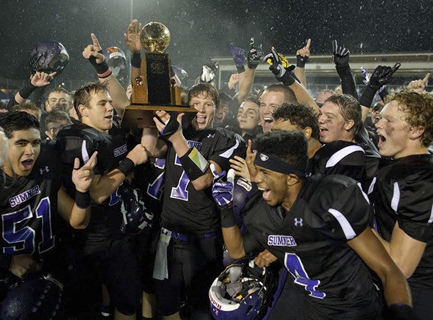 The Sumner Spartans celebrate its 42-7 Sunset Bowl win over Bonney Lake Friday.