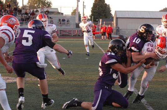 Sumner High’s Jon Mayer and Josh Wilde put the squeeze on Lion running back Skyler White Friday night. The Spartans won 28-13.