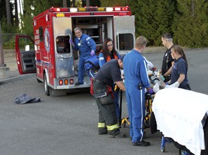 The driver of a car that rolled over is prepped for transport to the hospital.