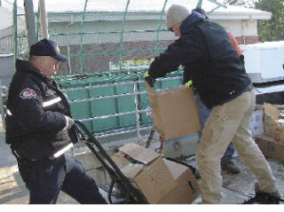 Mike Giefer from East Pierce Fire and Rescue and Zack Jones from the Bonney Lake Public Works Department load food at Bonney Lake High Dec. 16.