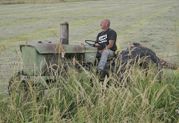John Van Wieringen worked his cut hay Friday preparing to get the field baled before the rain.