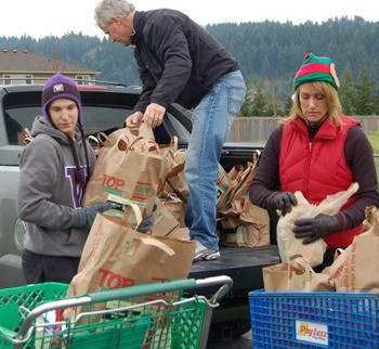 Last year's Tapps Island Food Drive brought in nearly a ton of food donations for the Sumner Food Bank. Pictured are Sumner High School Finnish foreign exchange student Tuure Heikkila