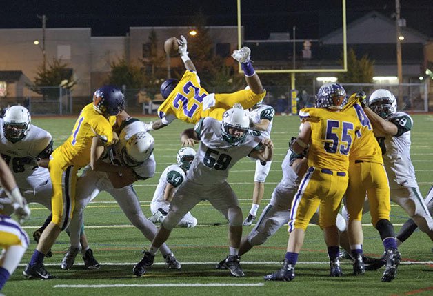 Sumner freshman Emmanuel Fidecaro jumps over the Peninsula defenders Friday. The Spartans lost the game in overtime 26-20.