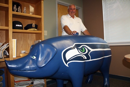 Outgoing Bonney Lake Police Chief Mike Mitchell stands with his Seahawks pig