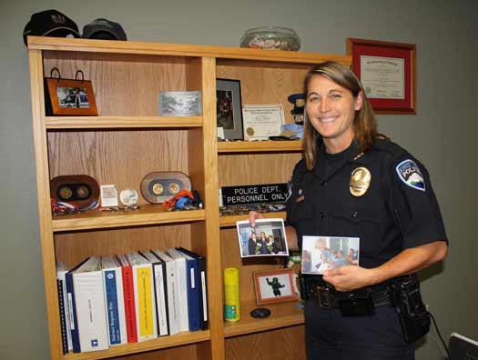 Bonney Lake Interim Police Chief Dana Powers displays some of the family photos she is placing around her new office.