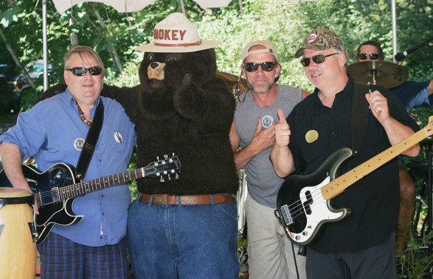 Members of the bank Howling Rain with Smokey the Bear at Kanaskat Palmer State Park Saturday at the Rock the Green benefit for the Middle Green  River Coalition. The members of the band are Left guitar player (blue shirt and shorts): Darrell Vernon bongo/cow bell: Randy Martin Drummer: Alan Kochevar Bass: Bernie McKinney