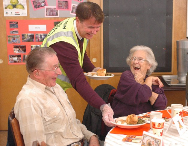 Enumclaw School District Superintendent Mike Nelson serves a Turkey dinner with all the fixin's Wednesday at the Enumclaw Senior Activity Center.