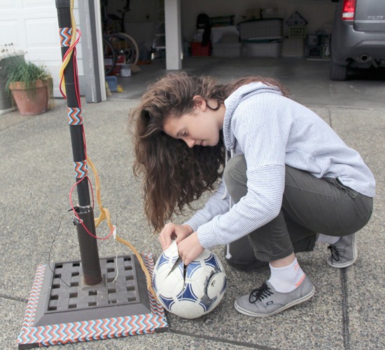 Amelia Day makes some adjustments to the electronics in her Press-Sure Soccer Ball