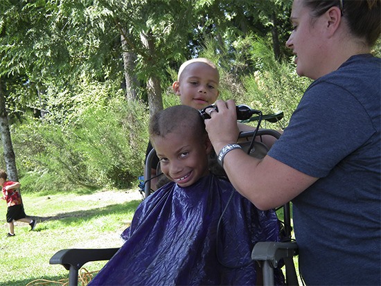 Jay Thomas getting his hair shaved before he plays football.