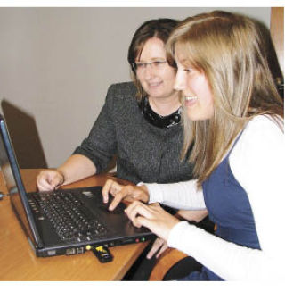 Hannah Brobak works with Lora Butterfield on members’ Facebook pages through a REACH-sponsored summer program.