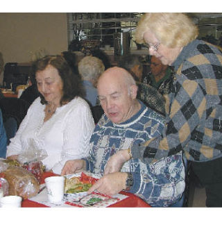 Shirley Green serves dinner to Laura Pete and Bob Englander Thursday during the Sumner Senior Center’s postponed holiday dinner. Bill Monroe