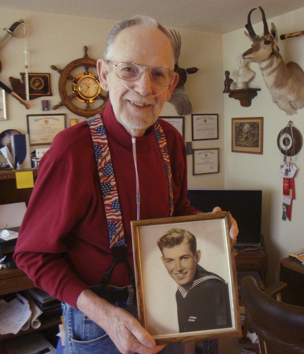Jack Warren holds a photo taken while he served in the US Navy.