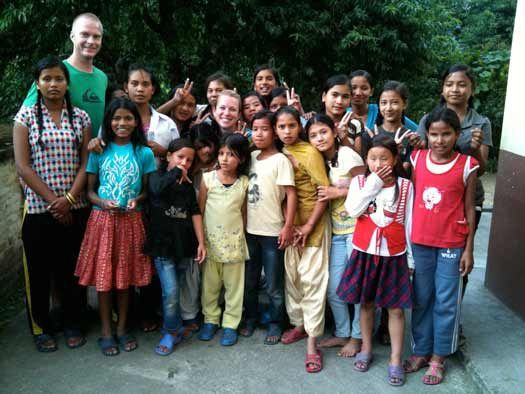 Laura Handy-Nimick and Justin Nimick pose among students during a trip to the Nepal Orphans Home.