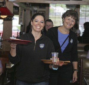 Police Records Clerk Jamie Amsbaugh and Administrative Assistant Louise Emry clear plates during a flapjack fundraiser July 14 at Applebee's.