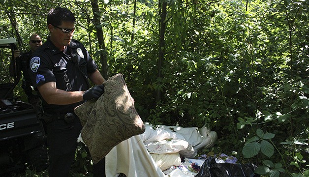 Bonney Lake Police Sgt. Ryan Boyle searches a small WSU forest encampment south of Goodwill.