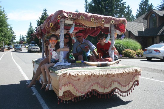 A family rides around the Tapps Island Garage sale on their custom golf cart.