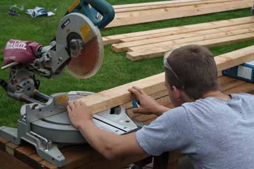A volunteer carefully lines up a stud for the perfect cut during the Pomegranate construction session Friday.