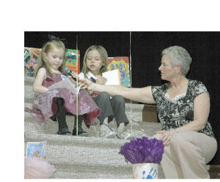 Enumclaw High School graduate Hans Nelson welcomed patrons with his  rendition of “Somewhere Over the Rainbow” on the ukulele to the Find A Way fundraiser for the Enumclaw School District’s all-day kindergarten program Sunday evening at the Enumclaw Expo Center fieldhouse. Enumclaw School Board Vice President Nancy Merrill sat and read with kindergarten students Kaetlyn Marlow from Southwood Elementary School and Ashley Crawford from Black Diamond Elementary School. The dinner-auction raised more than $50